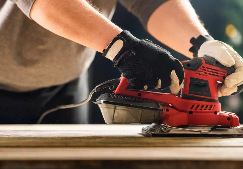 Power Sander in action smoothing wooden surface